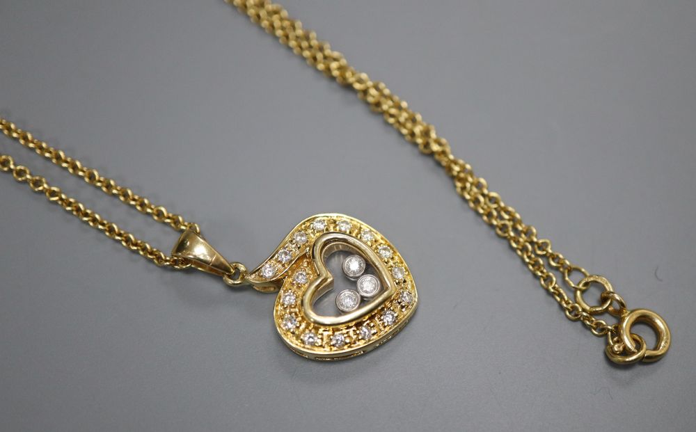 A modern Chopard style 18k and floating diamond set heart shaped pendant, on a 750 chain, pendant 18mm, gross 8.3 grams.